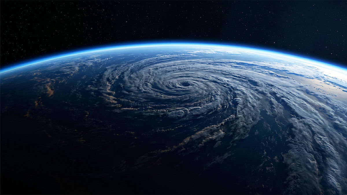 A spiral storm system over a dark ocean seen from orbit — the planet's hidden weather observed from above